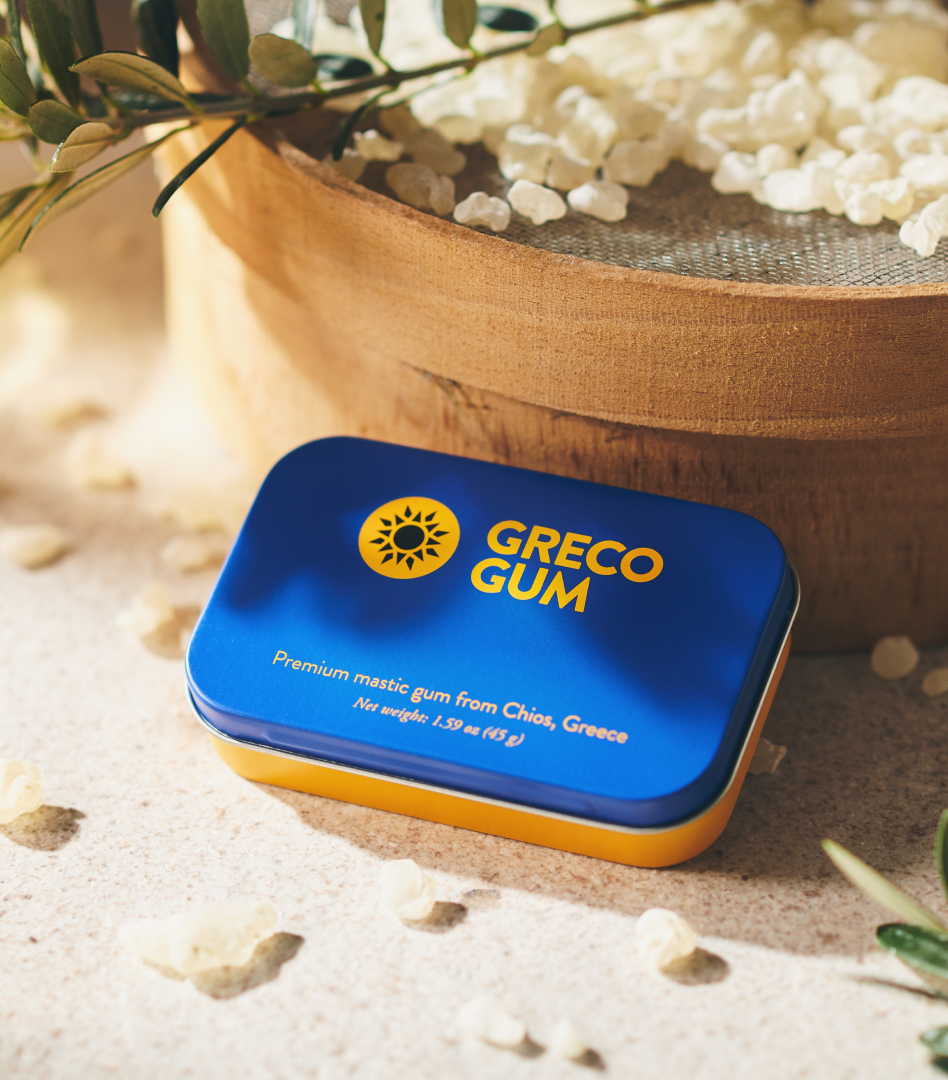 Greco Gum tin in blue and ochre, surrounded by mastic gum