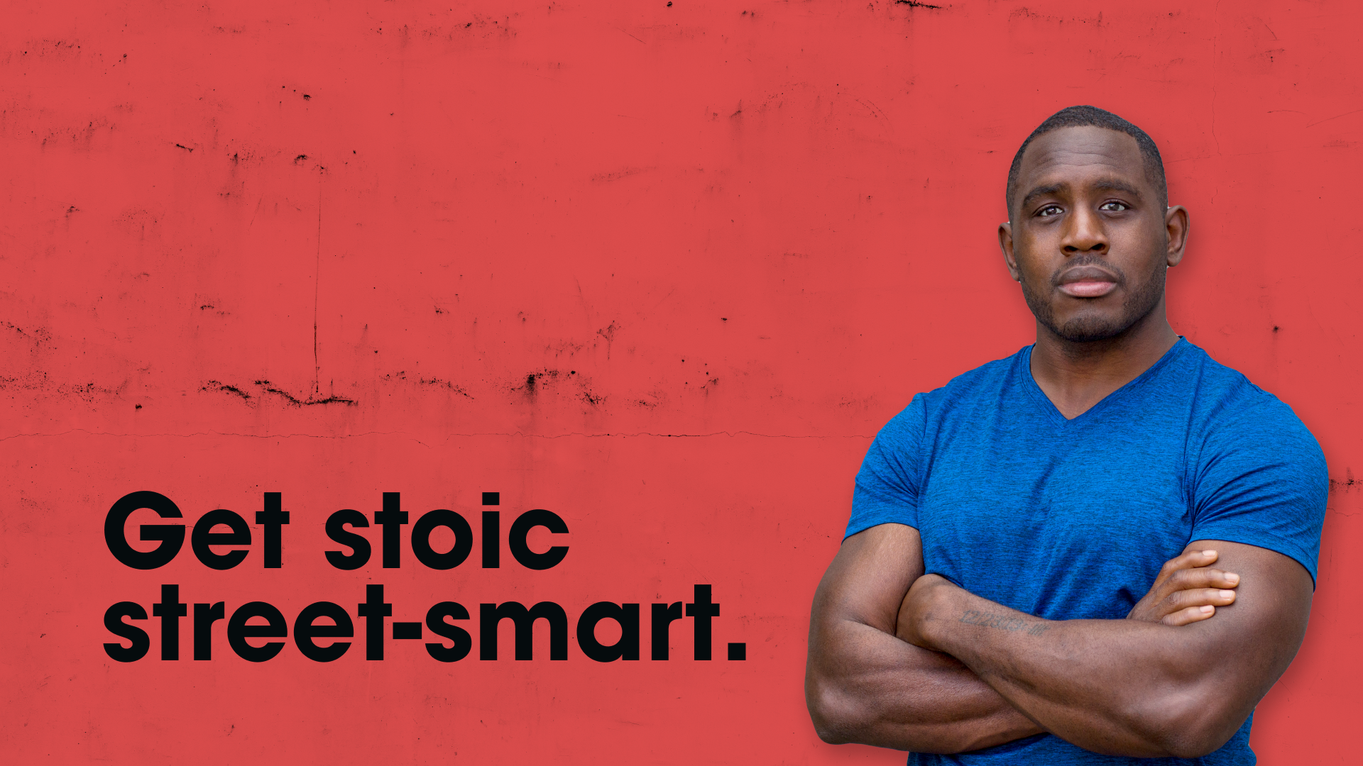 Photo of Ed Latimore standing in front of a red concrete wall with his signature tagline, "Get stoic street-smart," printed on top of it
