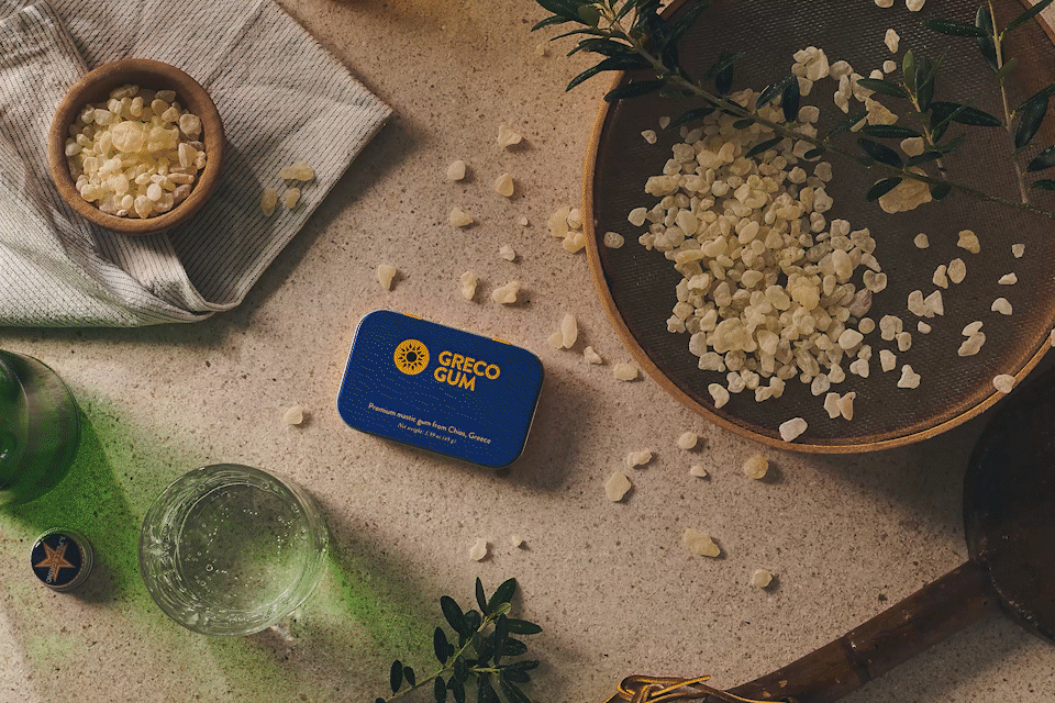 Packaging Looped video showing the Greco Gum tin surrounded by mastic gum, twigs, and sparkling water